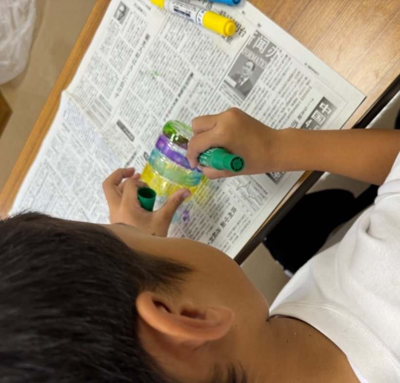 マジックでペットボトルに色を塗っている